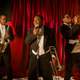 The Wu-Tang Clan performs with Lauren hidden behind a curtain in an all-men’s club.